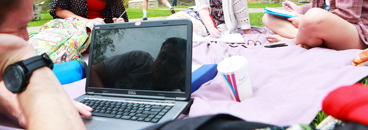 A Cabrini student on a laptop outside