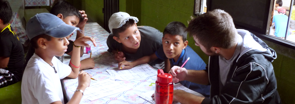 A Cabrini student with local schoolchildren in Ecuador during a service trip